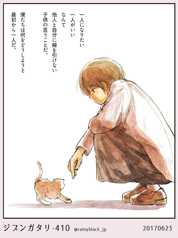 しゃがんで子猫に指を差し出す青年の横顔