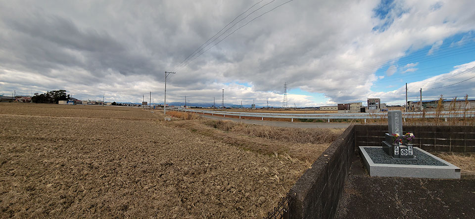 田んぼと墓石のある風景。