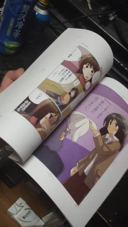 手に持たれたカラー漫画の開かれたページ