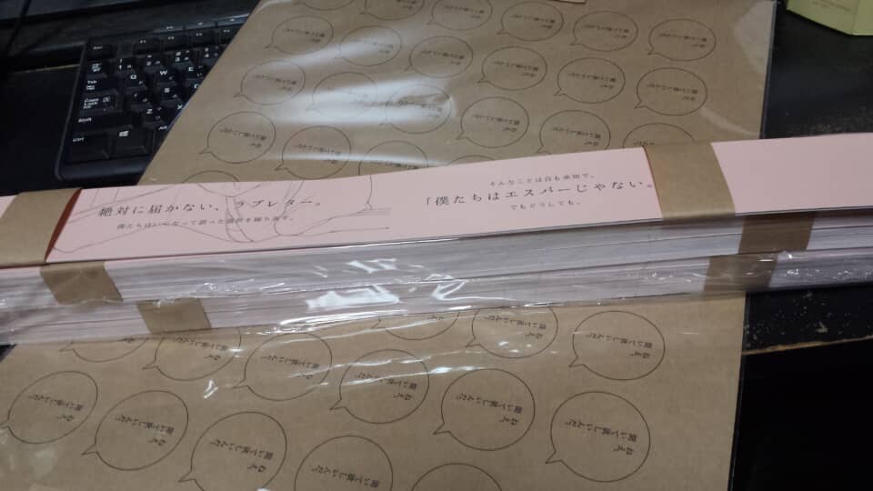 「絶対に届かない、ラブレター。」の帯が巻かれた冊子の束