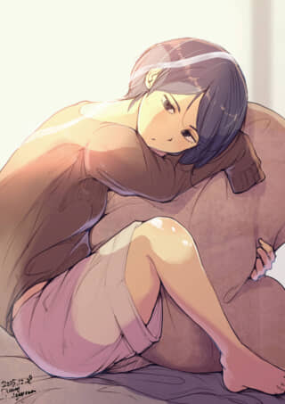 髪が短い女性が抱き枕に寄りかかる。