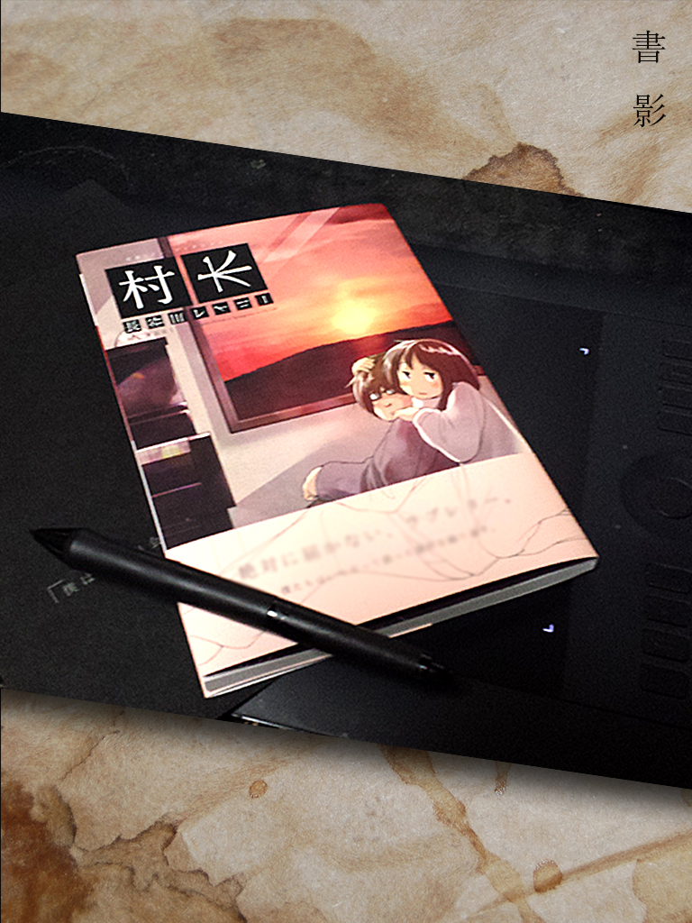 ペンタブレットの上に置かれた本『村長』と専用のペン
