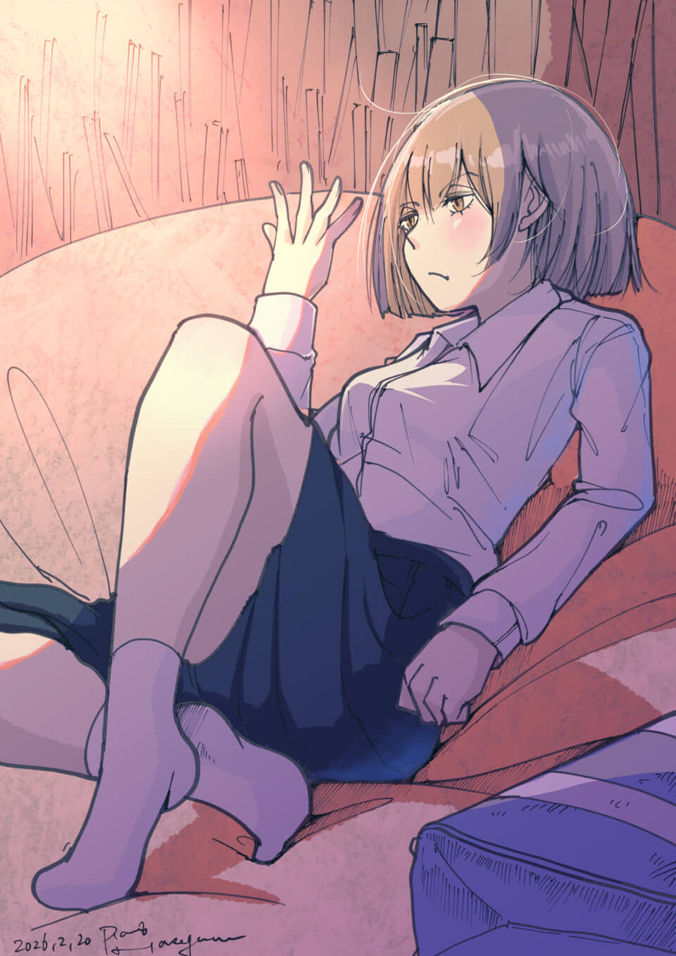 ソファに座り物憂げな表情のショートヘアの女性