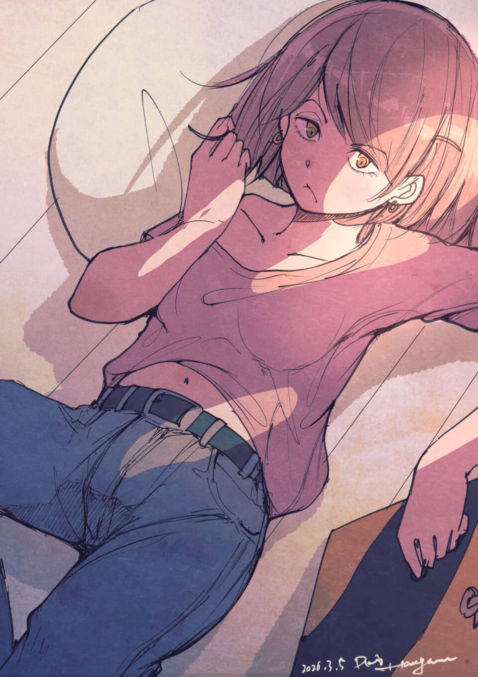 ピンクTシャツにジーンズ姿の女性が髪をいじり横たわる。